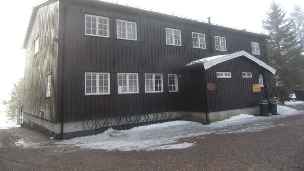 Hovedbygget sett fra vest, med en stor grusplass foran inngangen.