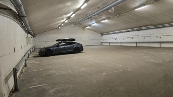 Bil står parkert inne i lagerlokalet.