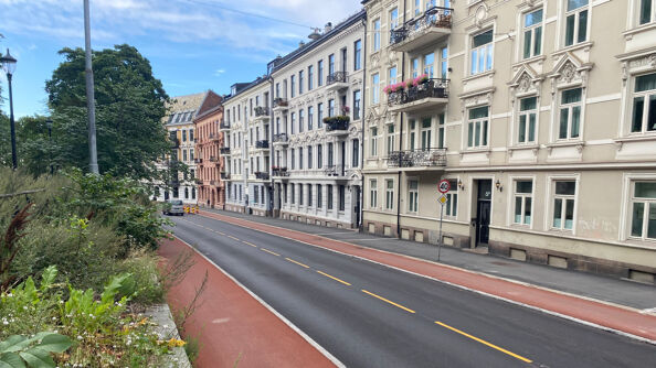 A photo of Ullevålsveien street in Oslo, with apartment buildings and a bike lane.