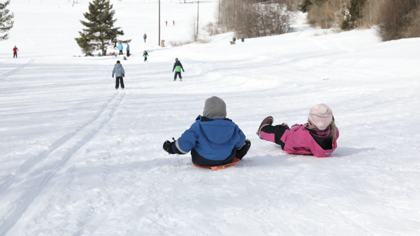 A photo of two children sledding down a hill in Oslo