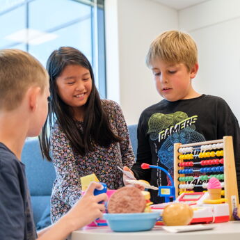 Tre barn som leker butikk