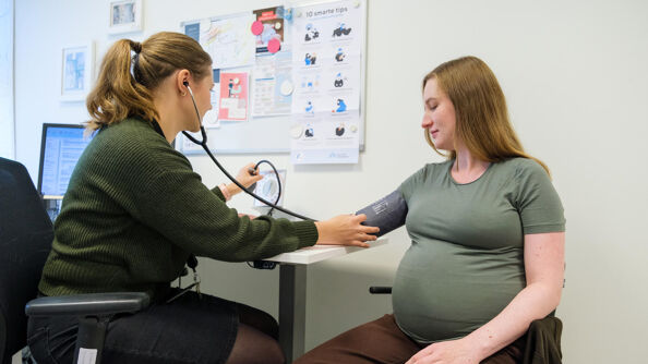 Gravid kvinne på svangerskapskontroll med jordmor