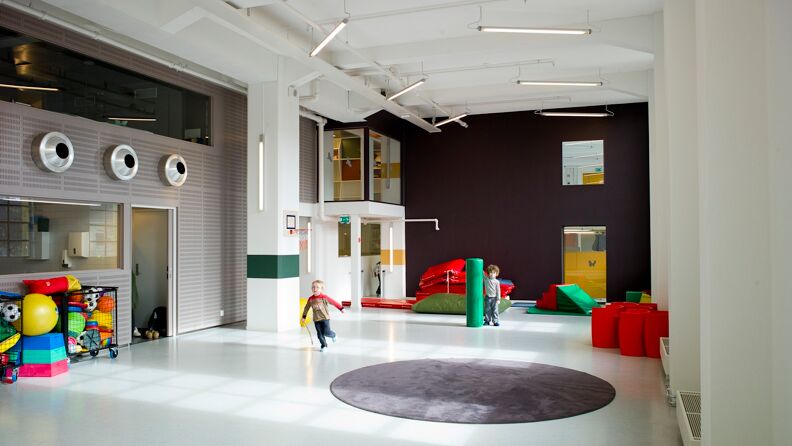 To barn som løper i gymsalen